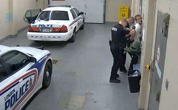 Nathaniel Veltman being searched at LPS headquarters June 6, 2021 (Screen capture from exhibit video courtesy of the Ontario Superior Court of Justice)