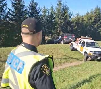 A tow truck removes a vehicle that crashed into the tree line on Highway 3 near Schafer Side Road in Norfolk County, May 2, 2024. Image courtesy of Norfolk OPP.
