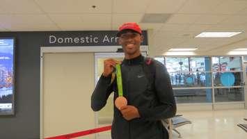 London decathlete Damian Warner shows off his Olympic bronze medal upon his arrival back from Rio at the London International Airport, August 24, 2016. (Photo by Miranda Chant)