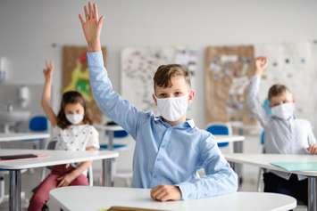 Students wearing face masks in the classroom. (© Can Stock Photo / halfpoint)
