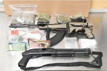 A semi-automatic rifle, 12 gauge shotgun, drugs and cash seized from a home on Limberlost Rd., October 18, 2017. Photo courtesy of London police.