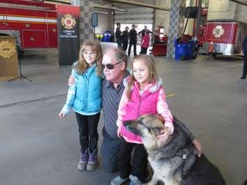 71-year-old Arko Ypma poses with his two granddaughters and his seeing eye dog Trooper at London Fire Station #1 on Horton St., January 27, 2017. (Photo by Miranda Chant, Blackburn News)
