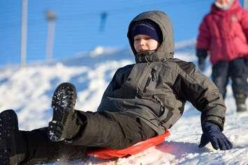 A little boy goes down a hill on a sled. File photo courtesy of © Can Stock Photo / yustoprst
