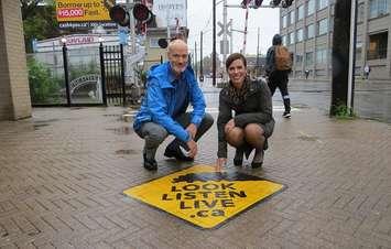 London's Director of Roads and Transportation Doug MacRae and Operation Lifesaver’s National Director Sarah Mayes show off a new railway safety decal in the downtown, September 25, 2018. (Photo by Miranda Chant, Blackburn News)
