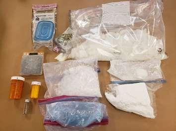 Various drugs, brass knuckles and a digital scale seized during police raids at three London homes, April 14, 2022. Photo courtesy of London police.