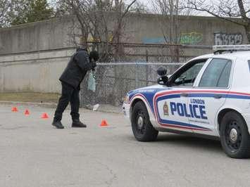 A London police forensics officer photographs evidence following a stabbing near Saunders Secondary School, March 9, 2017. (Photo by Miranda Chant, Blackburn News.)