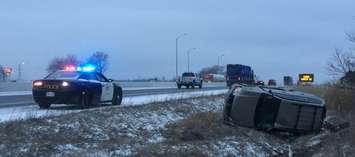 A vehicle lays on its side in the ditch along Highway 401 in the London-area, March 16, 2021. Photo courtesy of OPP.