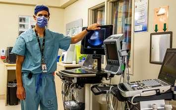 Dr. Robert Arntfield stands with a portable ultrasound unit. Photo courtesy of Lawson Health Research Institute. 
