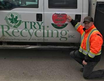 TRY Recycling  Sites  Supervisor Chris Humphries installing the frontline worker decal to one of TRY's vehicles. Photo courtesy of TRY Recycling.