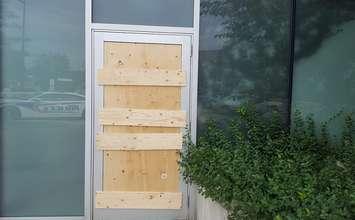 An exit door at London Police Headquarters is boarded up after it was damaged by a man in an attempted break-in, July 26, 2018. Photo courtesy of London police.
