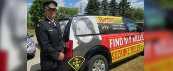 OPP Detective Superintendent Ken Leppert stands beside a minivan wrapped with information about the 1974 murder of Suzanne Miller, July 19, 2018. (Photo by Miranda Chant, Blackburn News)