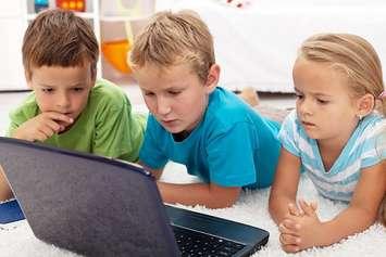 Children work on a laptop. File photo courtesy of © Can Stock Photo / ilona75.