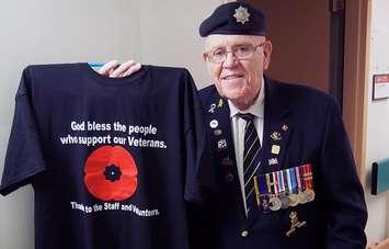 Retired Master Corporal Ed Duffney displays one of the t-shirts he designed and sells to raise money for veterans. Photo courtesy of St. Joseph’s Health Care Foundation.