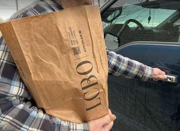 A customer carries an LCBO paper bag to their vehicle. (File photo by Miranda Chant, Blackburn Media)