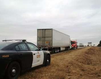 OPP officers stop a tractor trailer on Hwy. 401 near the Colonel Talbot Rd. exit in London. (Photo courtesy of the Ontario Provincial Police)