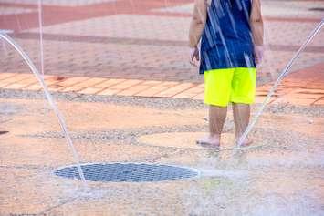 Child playing in spray pad. Photo courtesy of © Can Stock Photo / liveslow