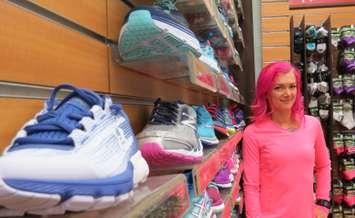 Angie Hopf, store manager of the Running Room on Richmond St. shows off the store's many running shoes, April 17,
 2017. (Photo by Miranda Chant, Blackburn News.)
