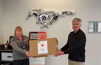 Lambton Ford Owner Rob Ravensberg presents Bluewater Health Foundation's Johanne Tomkins with over 100 face shields. (Photo courtesy of BWH Foundation)
