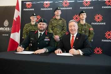 Canadian Army Reserve soldiers from 31 Canadian Brigade Group stand behind Colonel Jason Guiney of the Canadian Armed Forces and Fanshawe President Peter Devlin as they sign a Memorandum of Understanding on February 21, 2020. (Photo courtesy of Fanshawe College)